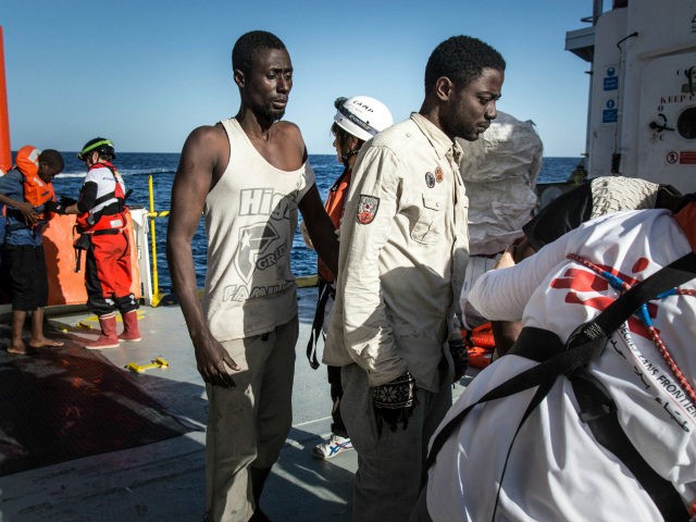 Migrants stand in line to register after being rescued aboard the MV Aquarius. 193 people