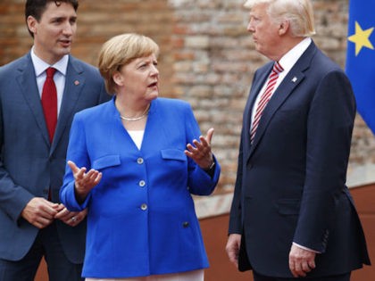 German Chancellor Angela Merkel, center, talks with Canadian Prime Minister Justin Trudeau, left, and President Donald Trump during a family photo with G7 leaders at the Ancient Greek Theater of Taormina during the G7 Summit, Friday, May 26, 2017, in Taormina, Italy. (AP Photo/Evan Vucci)