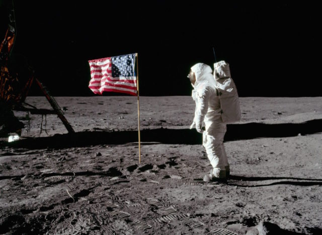 Astronaut Buzz Aldrin stands next to the deployed United States flag during the Apollo II