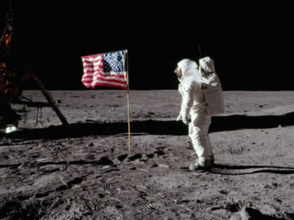 Astronaut Buzz Aldrin stands next to the deployed United States flag during the Apollo II