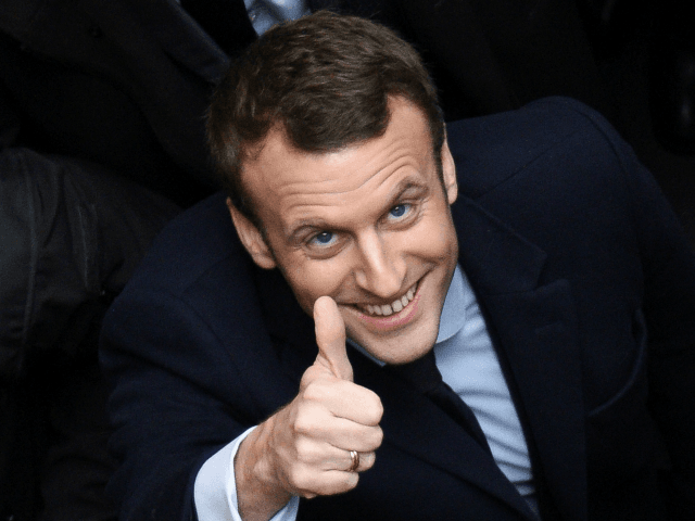 French presidential election candidate for the En Marche ! movement Emmanuel Macron (L) gives the thumbs up on March 14, 2017 as he arrives at Lille's university, northern France, to give a conference focused on justice.