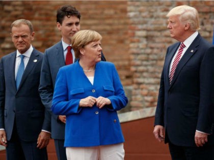 German Chancellor Angela Merkel talks with President Donald Trump during a family photo wi
