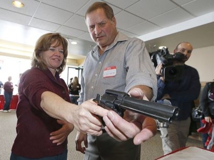 WEST VALLEY CITY, UT - DECEMBER 27: A Utah teacher is shown how to handle a handgun by instructor Clint Simon (R), at a concealed-weapons training class to 200 Utah teachers on December 27, 2012 in West Valley City, Utah. The Utah Shooting Sports Council said it would waive its …
