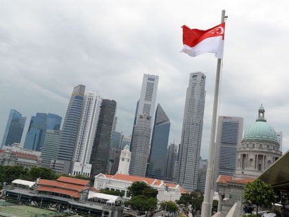 A Singapore national flag flutters above the National Gallery museum overlooking the financial district in Singapore on September 2016. / AFP / ROSLAN RAHMAN (Photo credit should read ROSLAN RAHMAN/AFP/Getty Images)