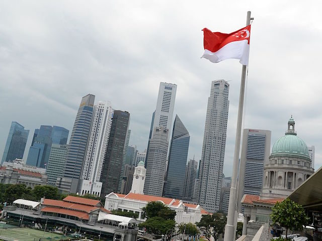 A Singapore national flag flutters above the National Gallery museum overlooking the finan