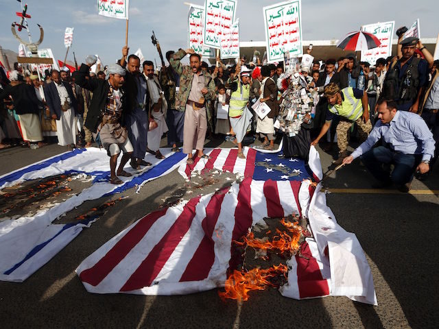 Yemeni supporters of the Huthi rebels burn Israeli and US flags as they shout slogans agai