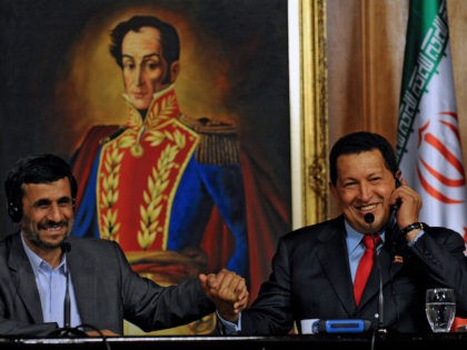Iranian President Mahmoud Ahmadinejad (L) holds hands with Venezuelan Presiden Hugo Chavez