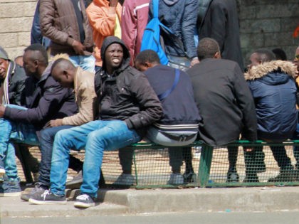 Migrant men outside of the makeshift migrant camp at Port de La Chapelle in Paris, France.