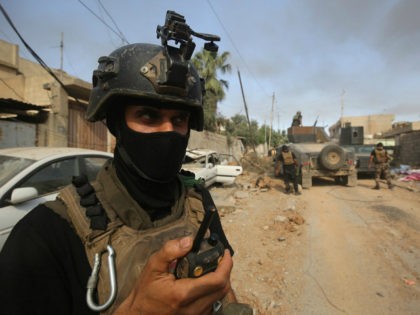 Members of the Iraqi Counter-Terrorism Service (CTS) take position as they advance towards