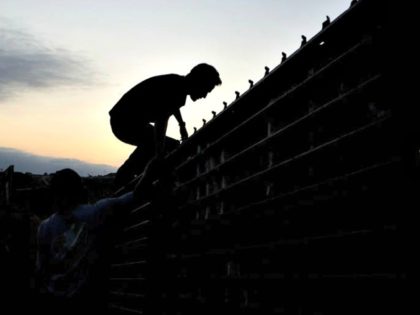 Man Climbs Border Fence AP