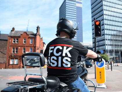 A man with a t-shirt that says 'FCK ISIS' on it waits at a red light on May 23, 2017 in Manchester, England.
