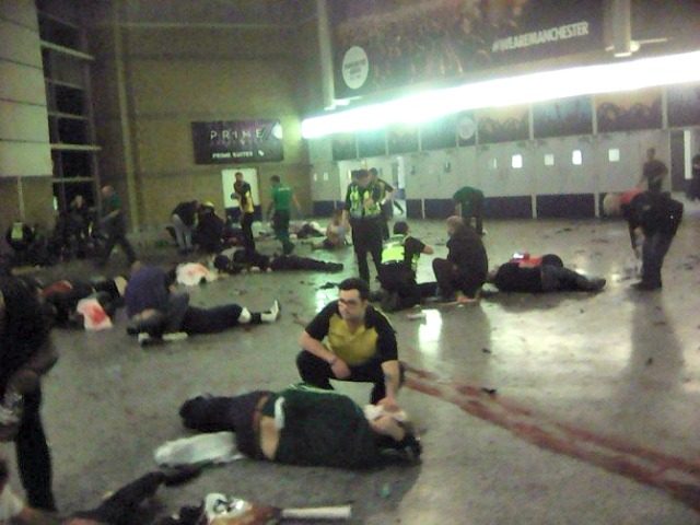Helpers attend to people inside the Manchester Arena after a suspected suicide bomber deto