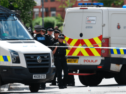Police officers work at the scene near a property they entered in the Moss Side area of Manchester on May 27, 2017 during an operation. British police said they arrested two more people during raids Saturday in connection with the suicide bombing at a Manchester concert, with a 'large part' …