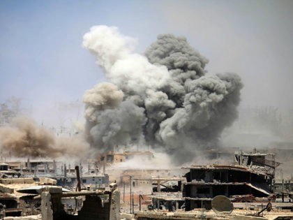 TOPSHOT - Smoke rises from buildings following a reported air strike on a rebel-held area