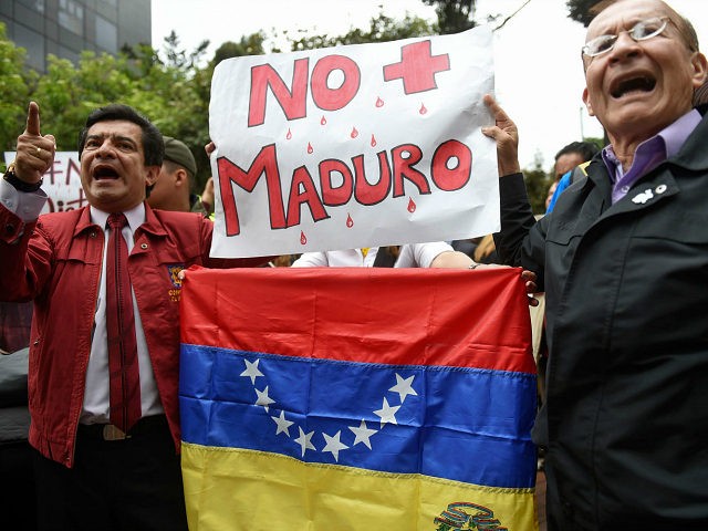 Venezuelans living in Colombia and local people protest against the government of Venezuelan President Nicolas Maduro, in Bogota, Colombia, on April 19, 2017. Clashes broke out Wednesday in Venezuela at massive protests against Maduro, as riot police fired tear gas to push back stone-throwing demonstrators and a young protester was …