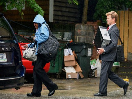 Federal agents exit the back of an office building after the FBI served a search warrant a