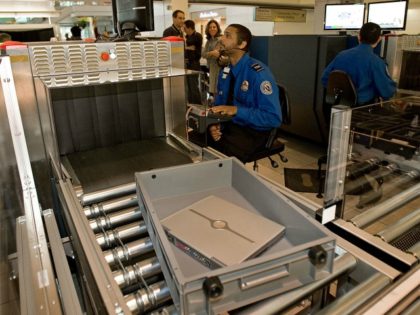 A Transportation Security Administration (TSA) officer reads the X-ray of a laptop compute