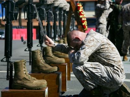 Corporal William Ward, a combat correspondent with the 1st Battalion, 1st Marines, holds the dog tags of fallen companions as the Marines of Regimental Combat Team 5 (RCT-5 ) memorialize 100 Marines, soldiers, and sailors who died during the regiment's 12-month deployment to fight in the Al Anbar Province of …