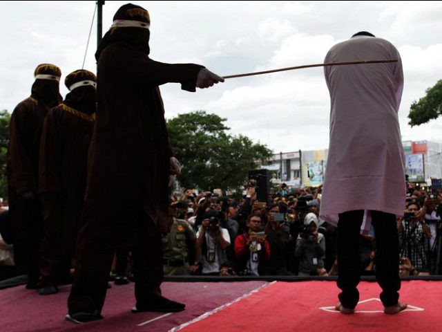 BANDA ACEH, INDONESIA - MAY 23: An Indonesian man gets caning in public from an executor k