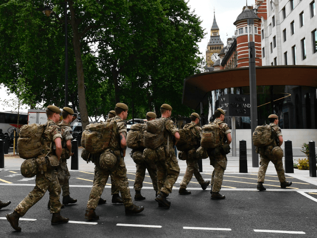 British soldiers arrive by bus and head toward a building next to New Scotland Yard police headquarters near to the Houses of Parliament in central London on May 24, 2017