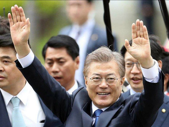 South Korea's new President Moon Jae-in waves to neighborhoods and supporters upon his arr