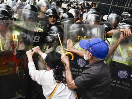 CARACAS, VENEZUELA, MAY 12: Opposition activists scuffle with riot police during a protest