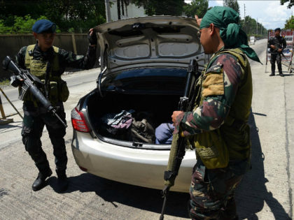 Philippine policemen check a car boot of a resident fleeing from Marawi city, where gunmen
