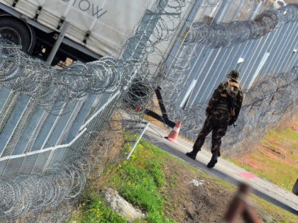 A Hungarian soldier patrols at the Hungarian border fence at the Tompa border station transit zone on April 6, 2017 as the Hungarian Interior Minister Sandor Pinter (not pictured) presents the camp to the media. The migrant transit complex on the Hungarian side of the border has been expanded to …