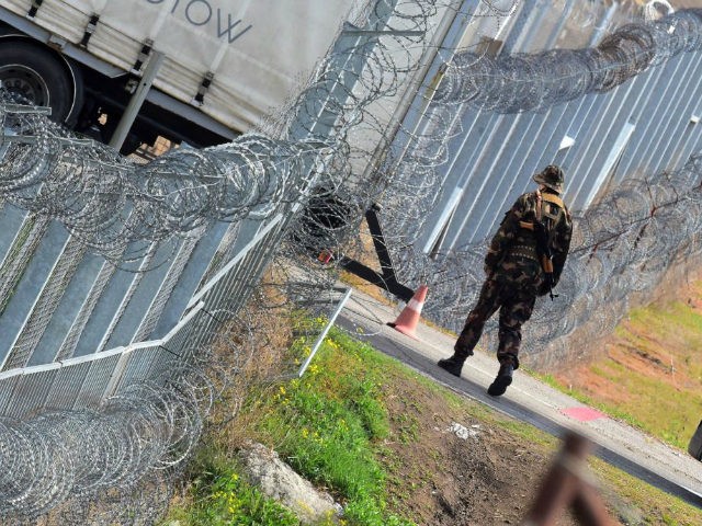 A Hungarian soldier patrols at the Hungarian border fence at the Tompa border station tran