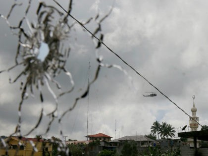 A military helicopter hovering by a mosque is seen through a shattered glass brought about by the fighting between government troops and Muslim militants who continue to hold their ground in some areas of Marawi city for almost a week Monday, May 29, 2017 in southern Philippines. Philippine forces control …