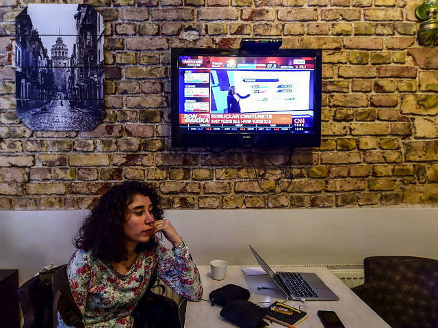 A woman follows the referendum results on television near Taksim square in Istanbul on Apr