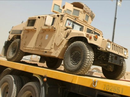 US army Humvees are loaded into trucks during a logistical operation to clear equipment an