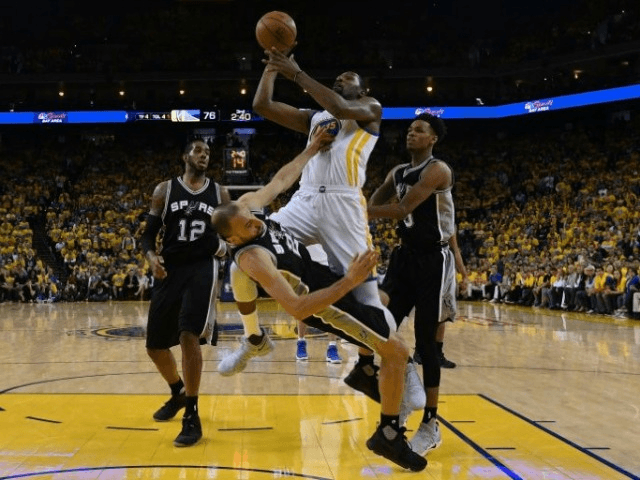 Manu Ginobili of the San Antonio Spurs draws a charge from Kevin Durant of the Golden Stat