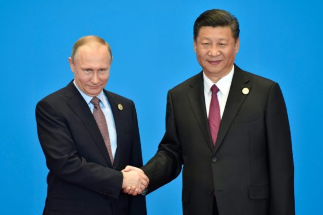 Russian President Vladimir Putin (L) praised his Chinese counterpart Xi Jinping's Silk Roa