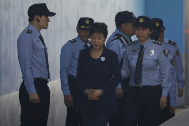 Handcuffed and on her way to court, the fall from grace for ousted South Korean president