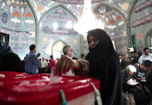 An Iranian woman casts her ballot for the presidential elections at a polling station in T