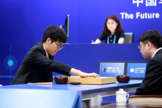 China's 19-year-old Go player Ke Jie (L) makes a move during the first match against Googl