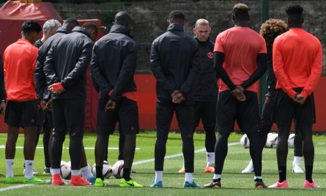 Manchester United players observe a minute's silence for the victims of yesterday's terror