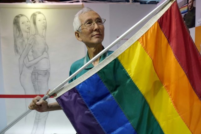 Taiwanese gay rights campaigner Chi Chia-wei, 59, poses for a photograph with a flag. Taiw