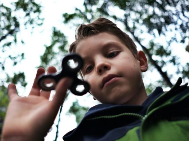 Eight-year-old Tom Wuestenberg plays with a fidget spinner in a park in New York on May 23