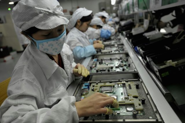 Workers assemble electronic components at a Foxconn factory