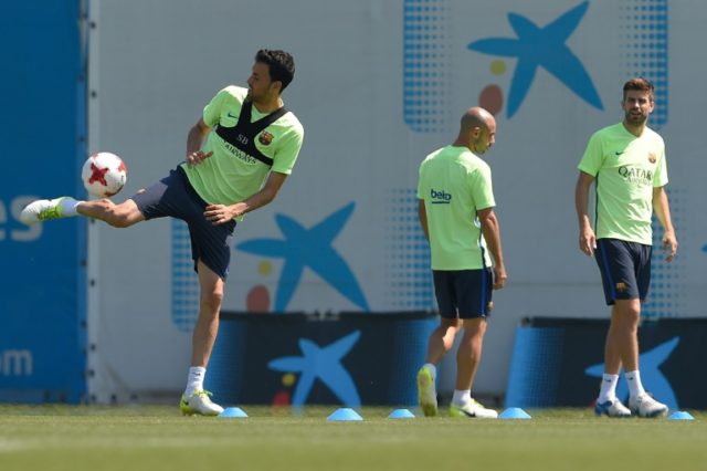 (From L) Barcelona's Sergio Busquets, Javier Mascherano and Gerard Pique take part in a tr