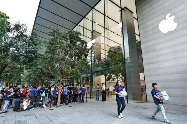 People queue outside the Apple store in Singapore's Orchard shopping district on its openi