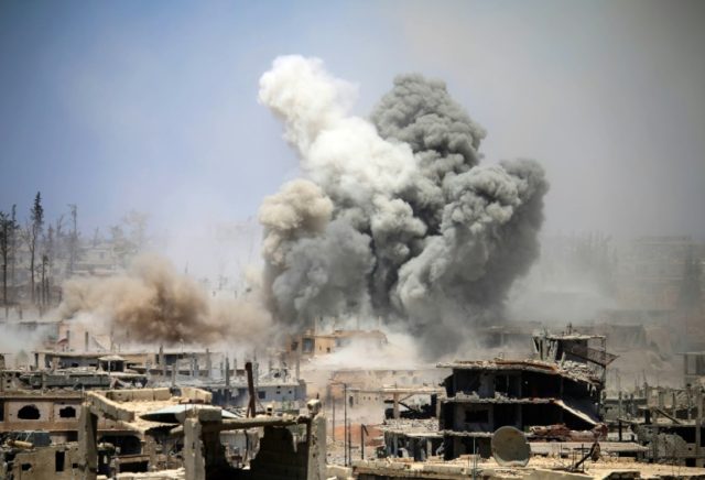 Smoke rises from buildings following a reported air strike on a rebel-held area in the sou