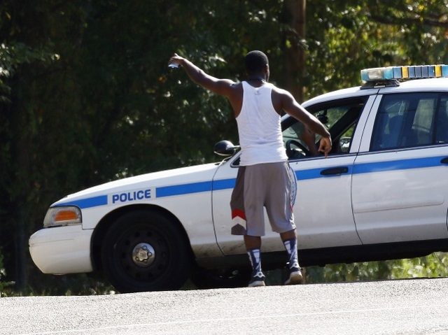 A resident gestures to a policeman as a police presence remains in a south Jackson, Miss.,
