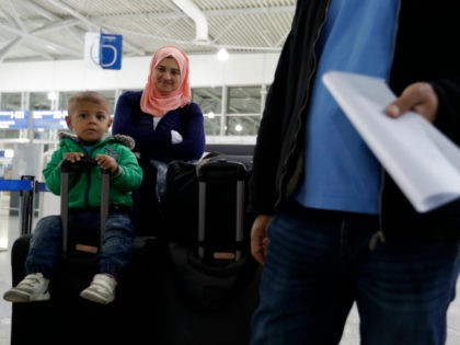 Syrian refugee Sumeya Akdrou smiles as she looks at her youngest son Elias sitting on a suitcase at the Athens airport before taking a flight to Madrid on Monday, Sept. 26, 2016. A group of 27 Syrians and four Iraqis was among the very few accepted by a European country …