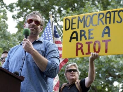 Mike Cernovich, left, a right-wing author and attorney, speaks during a rally outside the