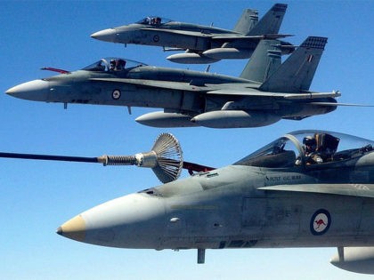 Three Australian Air Force (RAAF) F/A-18 Hornet fighter jets perform air-to-air refuelling