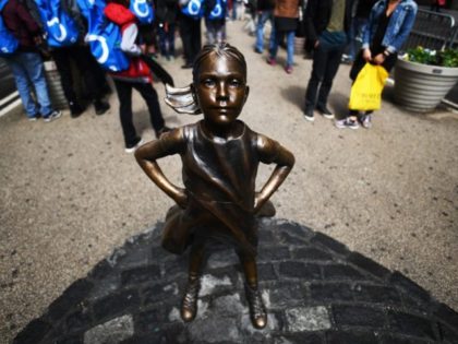 The "Fearless Girl" (front) statue stands facing the "Charging Bull" a