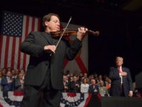 Luis Haza plays the US National Anthem as US President Donald Trump (R) listens at the Manuel Artime Theater in Miami, Florida, on June 16, 2017. Trump denounced Raul Castro's "brutal" Cuban regime on Friday in a speech to Cuban-American exiles vowing to restore "freedom" to their homeland. / AFP …